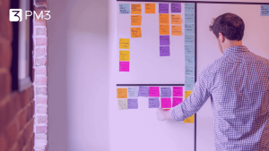 Homem colando post-its em quadro e aplicando Continuous Discovery Habits